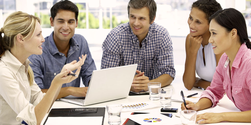 Várias pessoas reunidas em uma mesa discutindo entre si requisitos